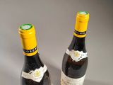 two bottles of wine sitting next to each other on a table