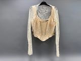 the back of a white shirt with lace on it, hanging on a hanger