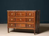 an antique chest of drawers with marble top in a dark room