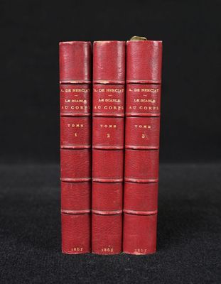 three red books sitting on top of each other on a black surface