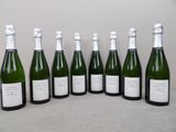 six bottles of champagne are lined up in a row on a table