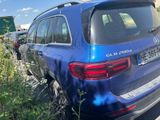 a blue mercedes suv parked on the side of the road