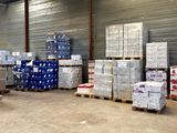 many pallets of boxes in a warehouse with pallets on them