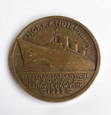 une pièce de bronze sur laquelle figure un bateau