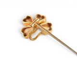 an image of a gold colored flower brooch with a long stem