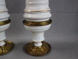 two white and gold vases sitting on a table