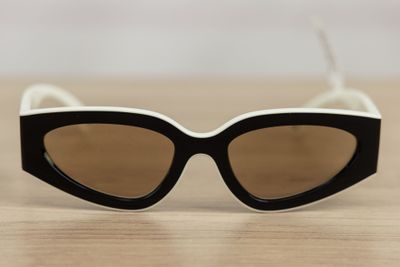 black and white cat eye sunglasses sitting on a wooden table