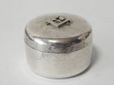 an old silver box with a cross on it sitting on a white surface