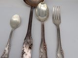 five silver spoons and two silver spoons on a table