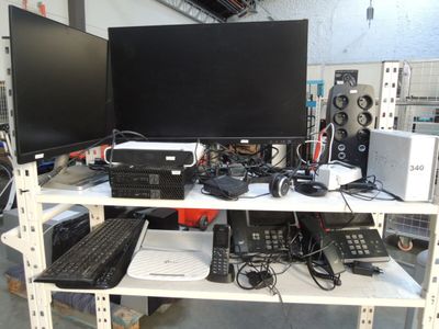 deux écrans et un clavier posés sur une étagère dans une pièce