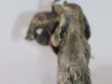 a small silver dog figurine on a white surface