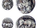 three silver coins with animals on them on a white surface