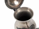 a silver pitcher with a lid on a white background