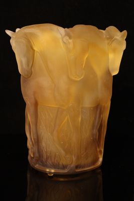a close up of a glass vase with a horse design on it