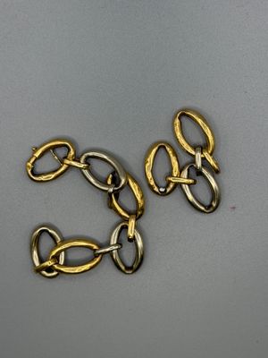 un gros plan sur une paire de chaînes en or posées sur une surface grise