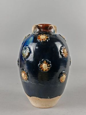 un vase bleu orné d'étoiles dorées, posé sur une table