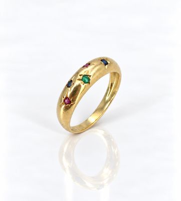 gros plan d'une bague en or avec des pierres multicolores