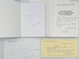deux livres ouverts, sur lesquels figurent des lettres manuscrites, posés sur une table