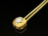 une image représentant un collier en or et en diamants posé sur un fond noir