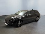 a black car is parked in a room with a white wall