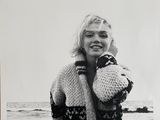 photographie en noir et blanc d'une femme tenant un ours en peluche sur la plage