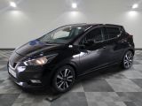la voiture noire est garée sur un sol en damier dans le garage