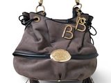 the purse is made of sued and has a gold buckle on the handle