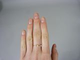 a woman ' s hand with a diamond ring on it