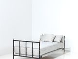a bed with a metal frame in a white room