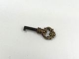 an old key is sitting on top of a white surface
