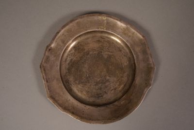 une assiette en argent accrochée au mur sur un fond blanc