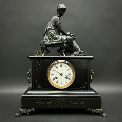 une statue de femme assise au sommet d'une horloge