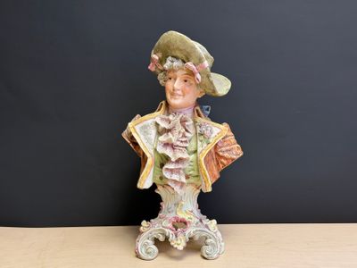 une figurine représentant une femme portant un chapeau et tenant un sac à main