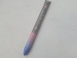 un stylo bleu et rose posé sur une surface blanche