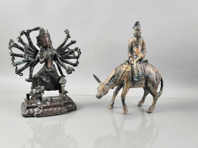 two figurines of a man riding a horse and a woman riding a cow