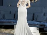 a woman in a wedding dress standing in front of a mirror