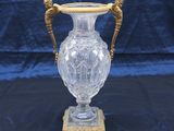 an antique glass vase with a gold handle on a stand