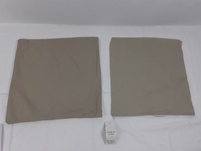 une paire de draps beiges sur un lit, avec une télécommande