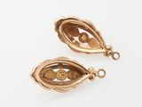a pair of gold - plated charms with an open eye