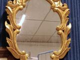 a mirror hanging on the wall next to a framed picture