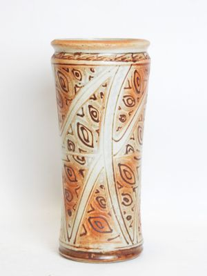a brown and white vase sitting on a white surface