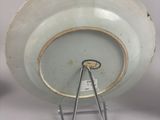 a white plate with a metal stand on a table