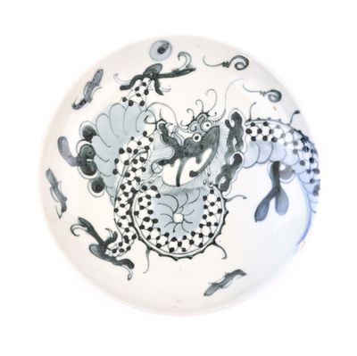 une assiette blanche ornée d'un motif représentant un dragon