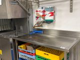 a stainless steel work table with a bunch of plastic containers on it