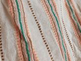a close up of a blanket on a bed next to a pillow