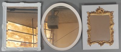 three mirrors hanging on the wall next to each other