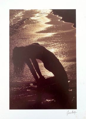 a picture of a woman bending over on the beach