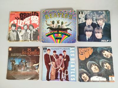 il y a beaucoup de pochettes d'albums des Beatles sur la table