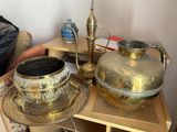 a table with a gold vase and a silver plate on it