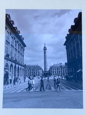 a black and white photo of a group of people crossing the street